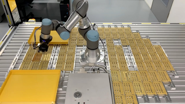 Roboterarm Cobot UR3e nimmt IR Strahler und platziert diese in einer Messvorrichtung