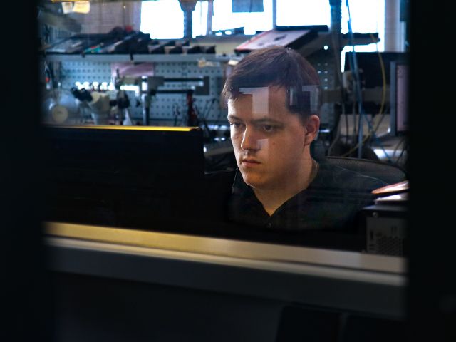 An employee in the assembly hall looks into the PC monitor.