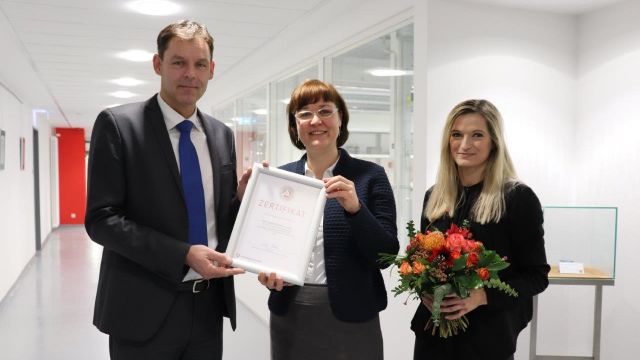 Mitarbeiter der Agentur für Arbeit übergibt das Zertifikat für Nachwuchsförderung an die Micro-Hybrid