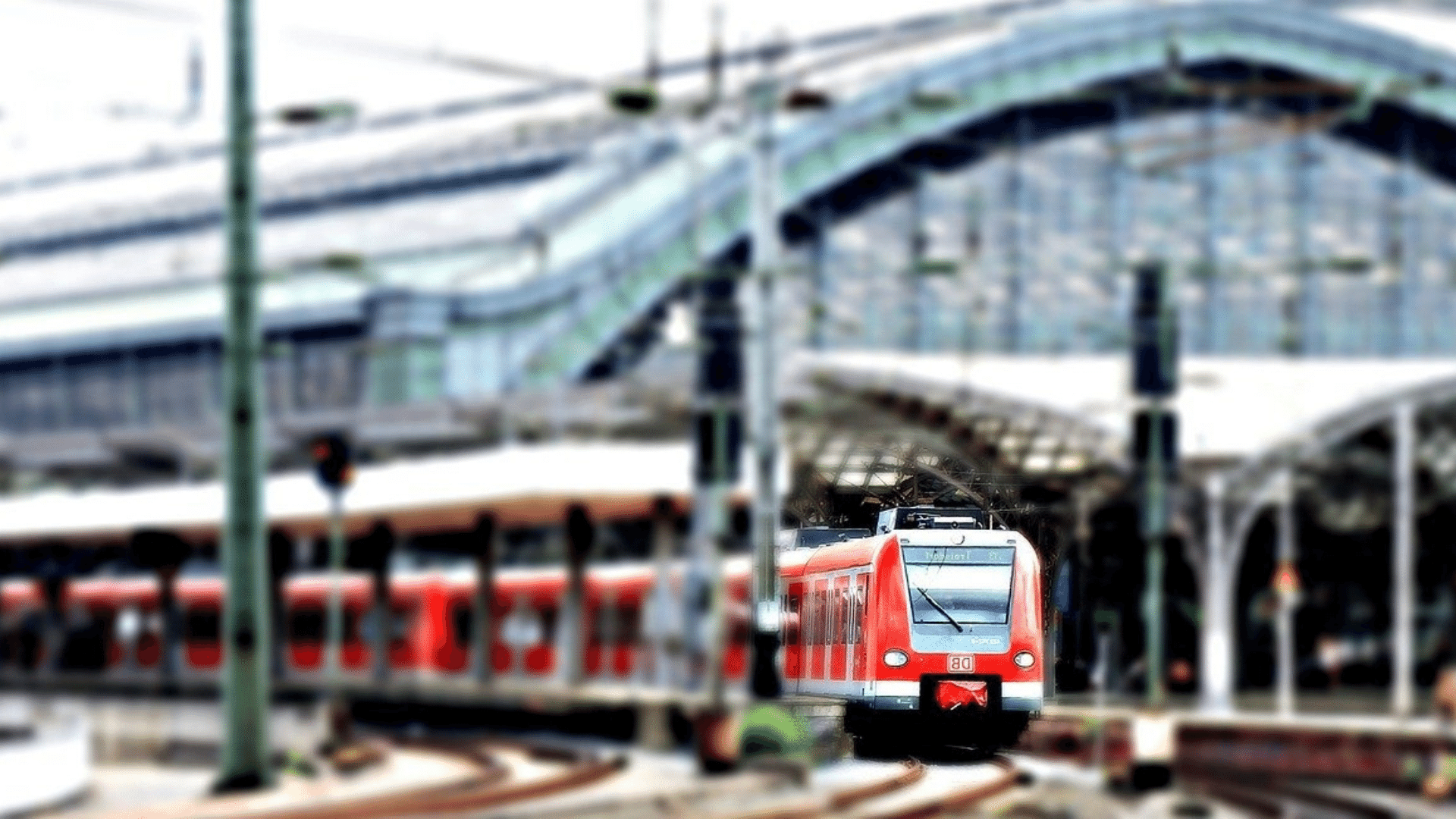 Eine S-Bahn der Deutschen Bahn fährt aus einem großen überdachten Bahnhof heraus