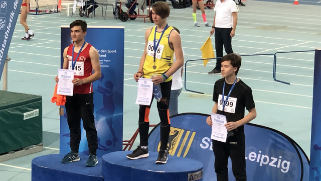 3 Schüler stehen auf dem Treppchen zur Siegerehrung, Silbermedaille für Luke Ortmann
