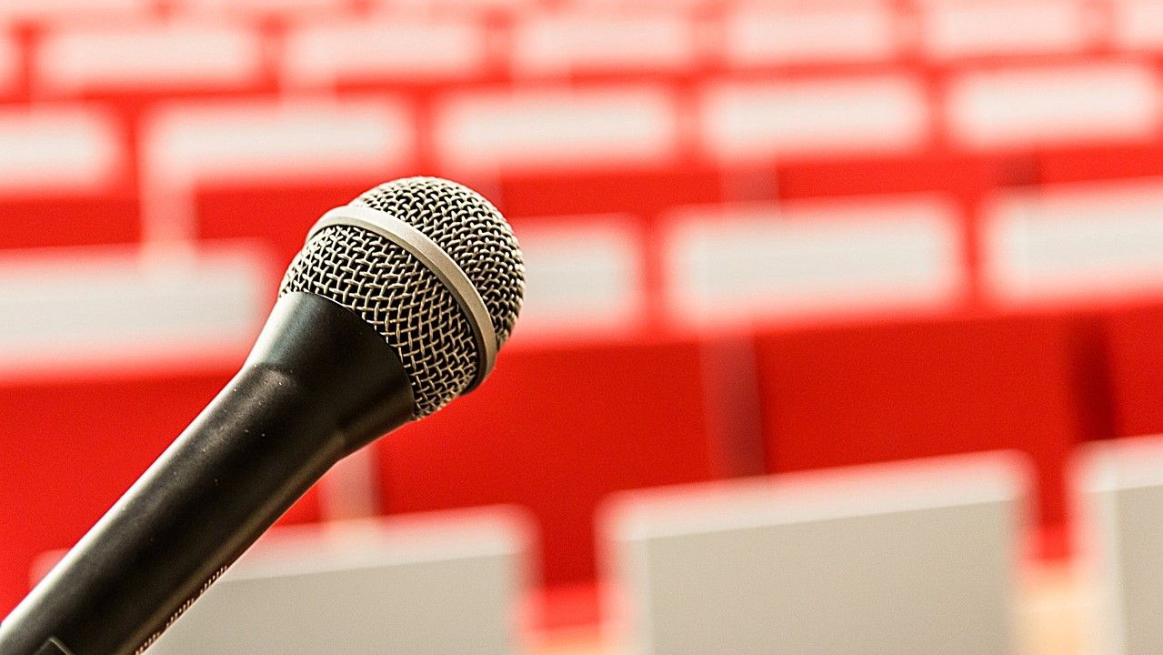 Mikrofon vor leeren Stühlen in einem Konferenzsaal