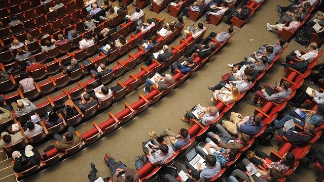 Ansicht von oben auf einen Hörsaal gefüllt mit Menschen