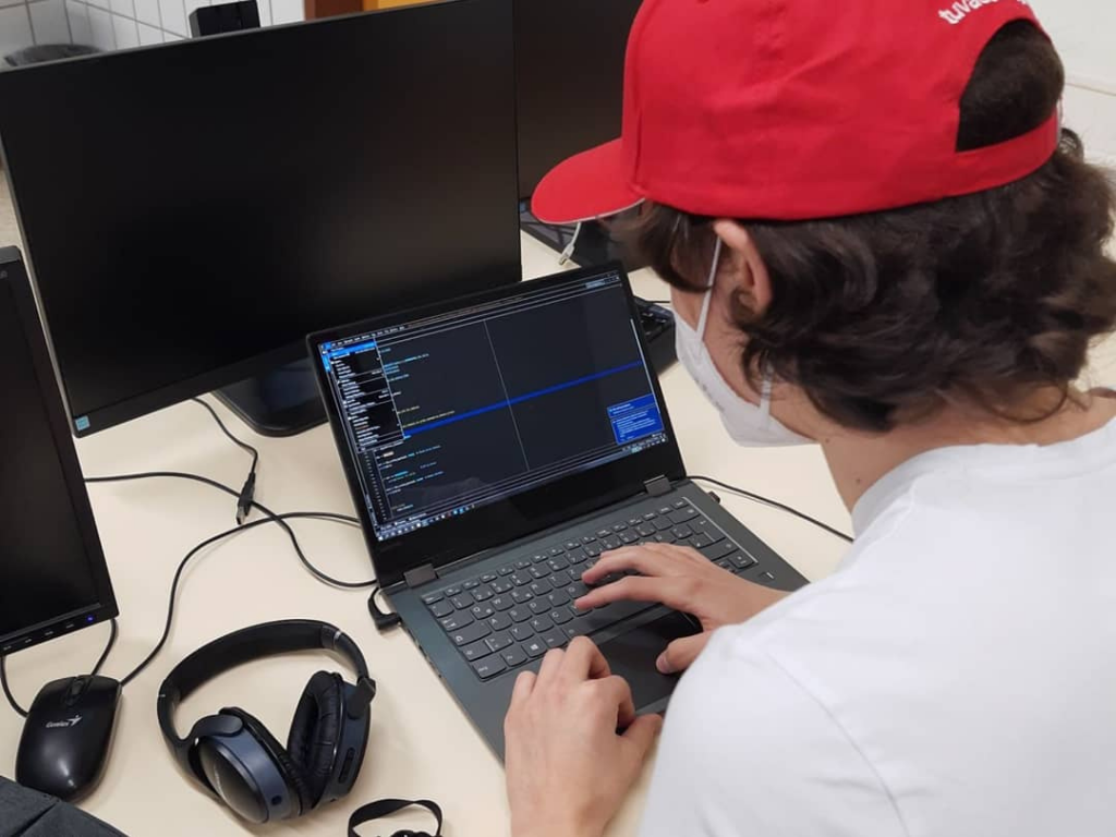 Mietglied des Team Cantaurus arbeitet am Laptop und programmiert